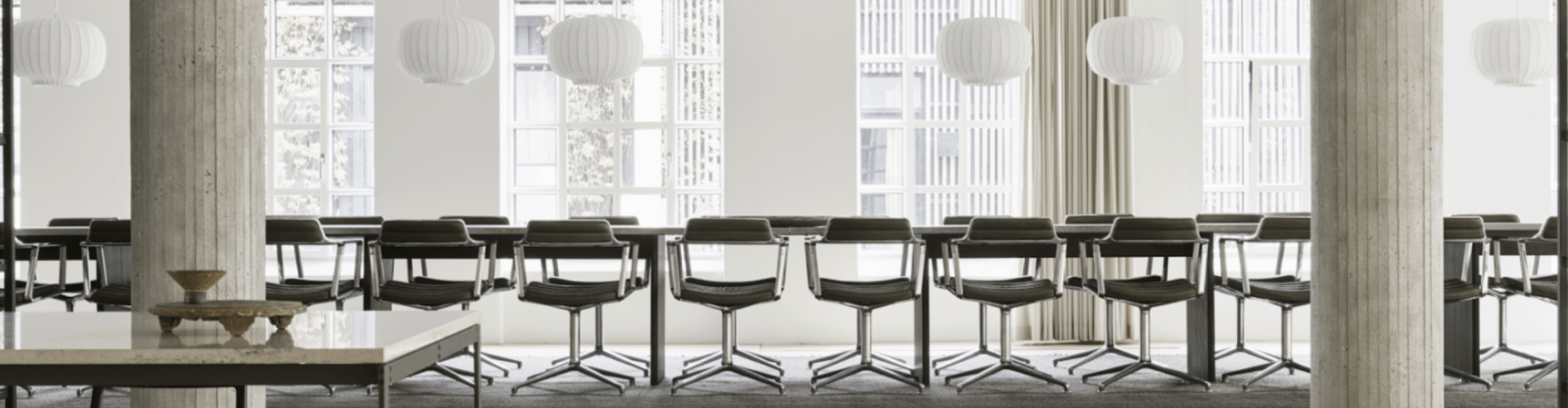 Una sala de conferencias con una gran mesa y sillas de diseño.