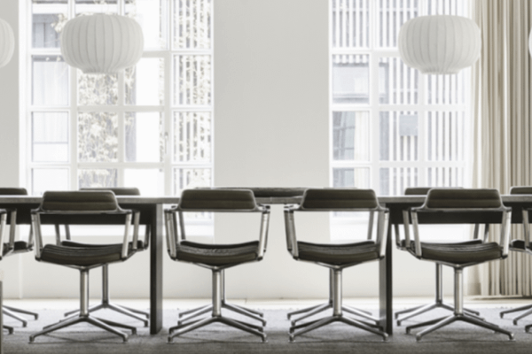 A conference room with a large table and designer chairs.